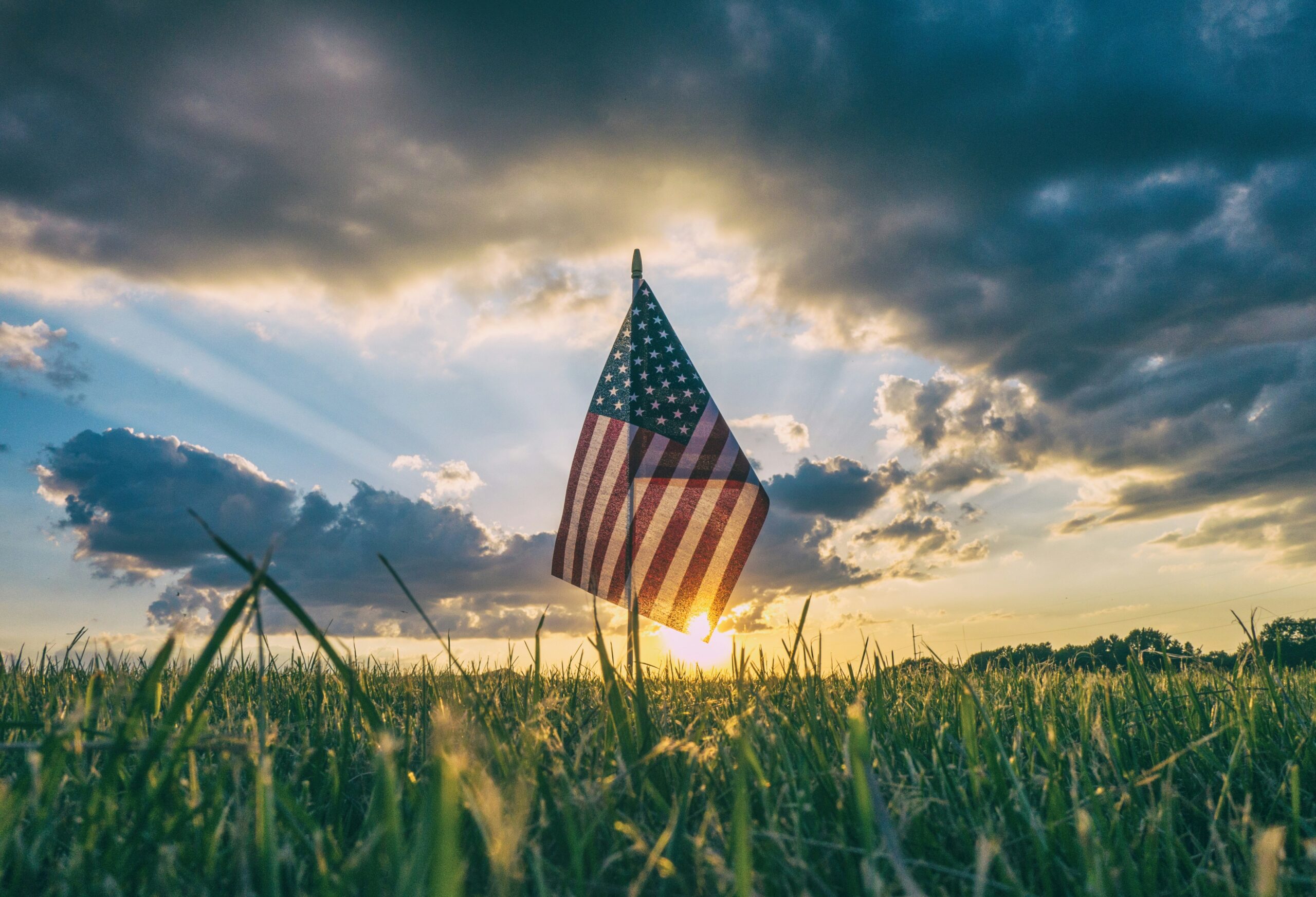 Photo by <a href="https://unsplash.com/@aaronburden?utm_source=unsplash&utm_medium=referral&utm_content=creditCopyText">Aaron Burden</a> on <a href="https://unsplash.com/photos/flag-of-usa-on-grass-field-9C8r4QUwZRQ?utm_source=unsplash&utm_medium=referral&utm_content=creditCopyText">Unsplash</a>      